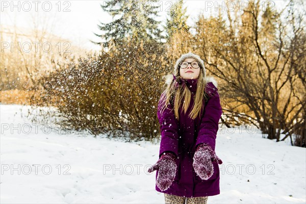 Caucasian girl looking up in snowy field