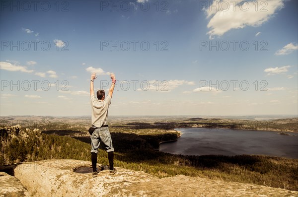 Caucasian man cheering on remote hilltop