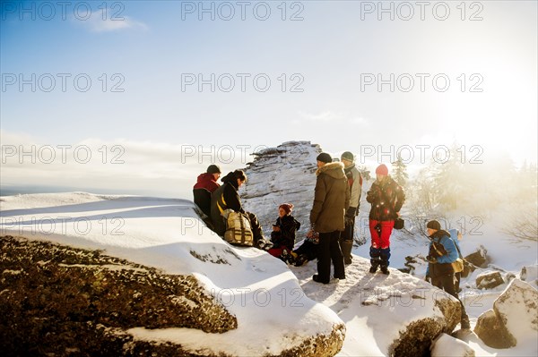 Caucasian hikers climbing snowy rock formations