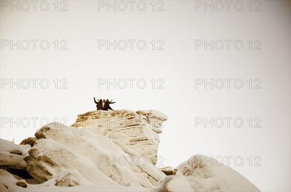 Caucasian hikers on snowy mountaintop