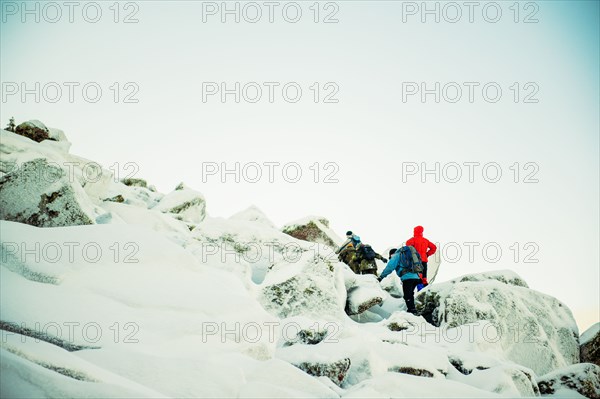 Caucasian hiker climbing snowy rock formations