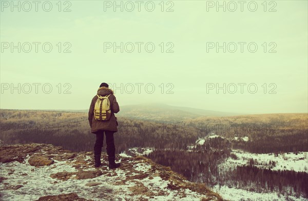 Caucasian hiker admiring scenic view from snowy mountaintop