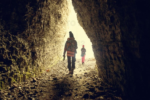 Caucasian hikers walking in rocky cave