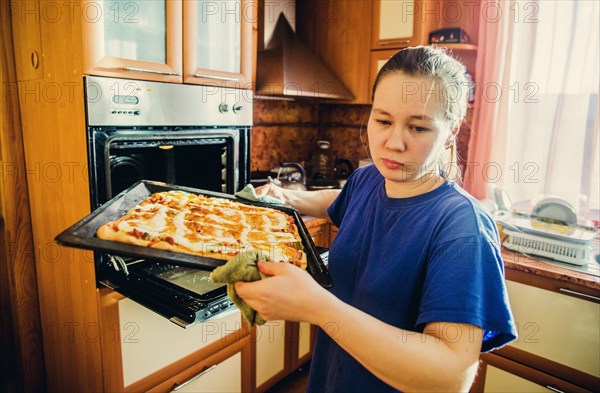 Caucasian woman cooking in kitchen