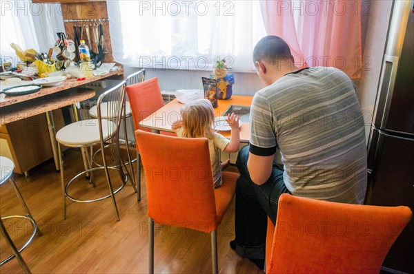 Caucasian father and daughter sitting in kitchen