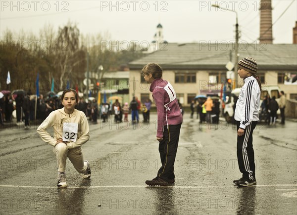 Caucasian children preparing for race on street