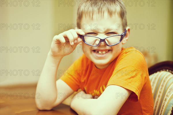 Caucasian boy peering over glasses