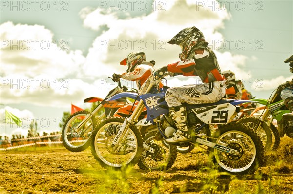 Caucasian motocross bikers riding on race course