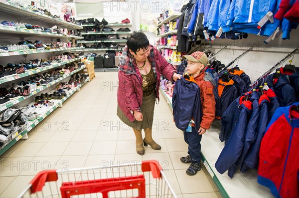 Caucasian grandmother and grandson shopping in clothing store