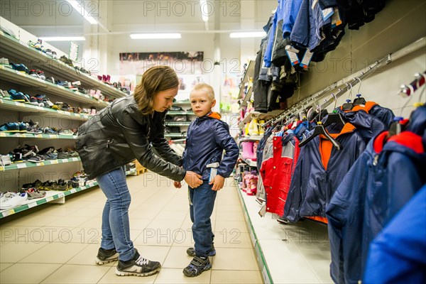 Caucasian mother and son shopping in clothing store