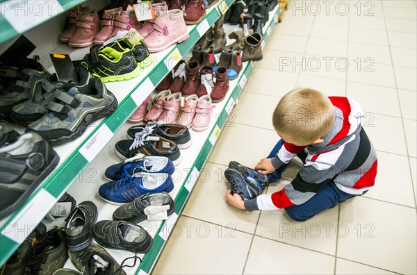 Caucasian boy shopping in shoe store
