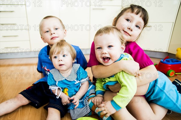 Caucasian children hugging on floor