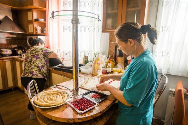 Caucasian mother and daughter baking in kitchen