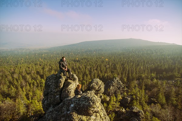 Caucasian hikers admiring view from remote rock formation