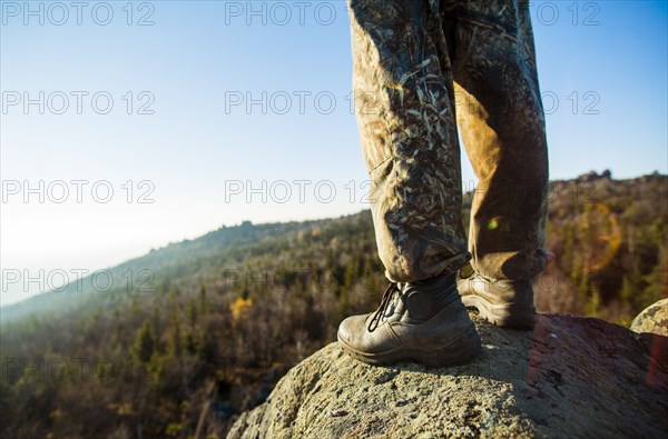 Close up of hiker standing on remote rock