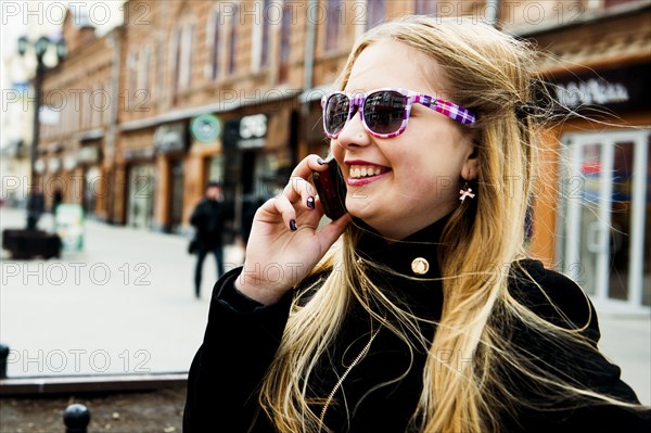 Caucasian woman talking on cell phone in city