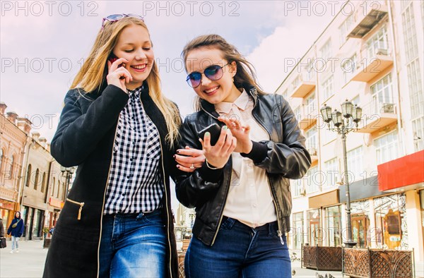 Women using cell phones in city