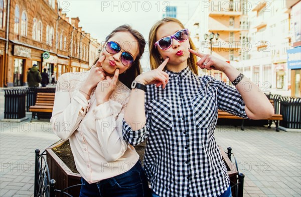 Women making faces in city