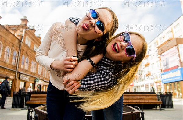 Women making faces in city