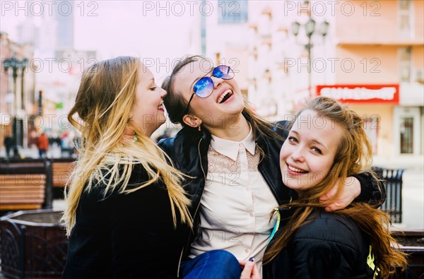 Smiling women hugging in city