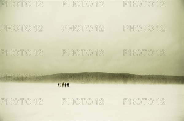 Caucasian hikers walking in snowy remote field