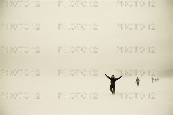 Caucasian hikers walking in snowy remote field