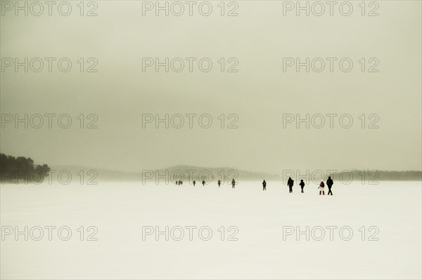 Caucasian hikers walking in snowy remote field