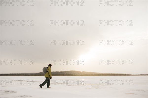 Caucasian hiker walking in snowy remote field