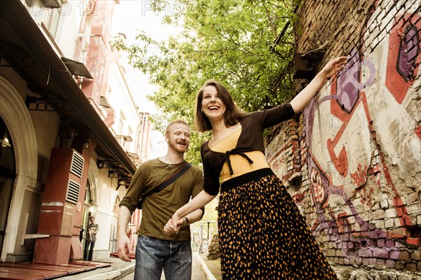 Caucasian couple playing in city street