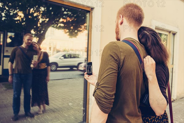 Caucasian couple taking self portrait in mirror