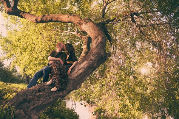 Caucasian couple kissing in tree