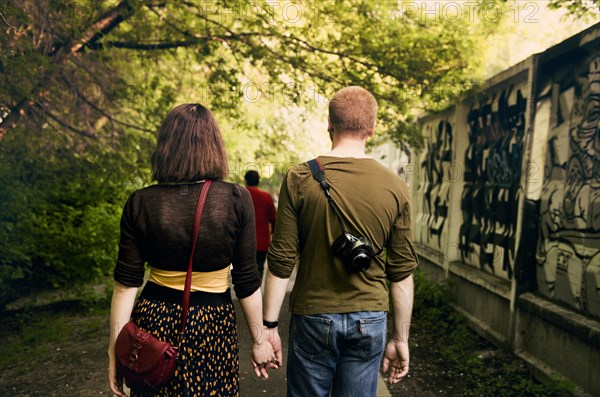 Caucasian couple holding hands in urban park