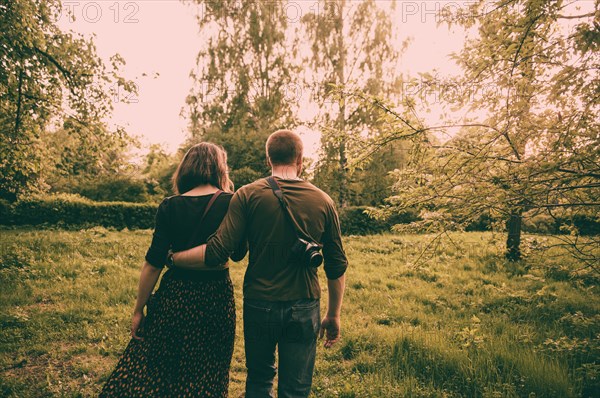 Caucasian couple walking in field