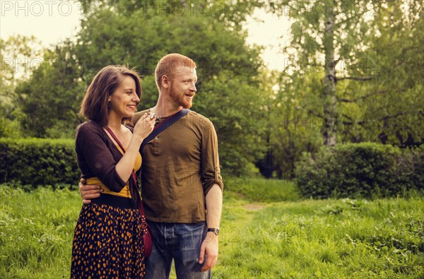 Caucasian couple hugging in field