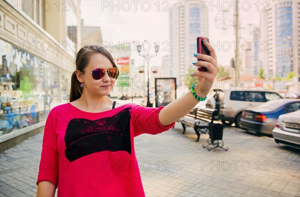 Caucasian teenage girl taking self portrait on cell phone