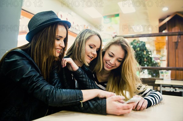 Caucasian women using cell phone in shopping mall