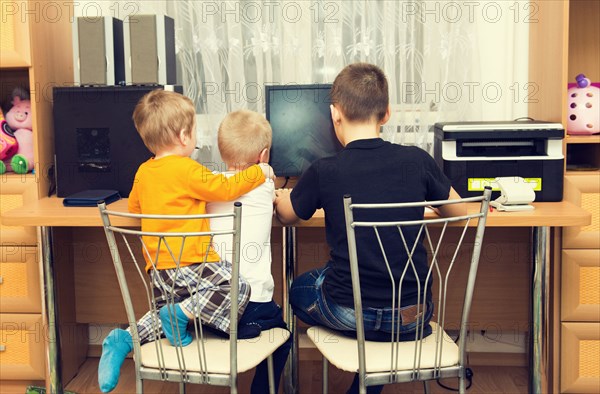 Caucasian brothers using computer in bedroom