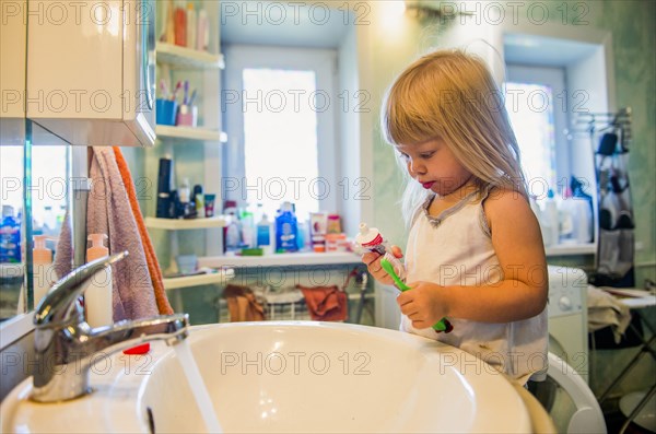 Caucasian girl brushing her teeth in bathroom