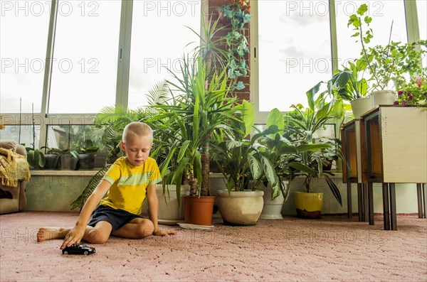 Caucasian boy playing with toy cars on floor