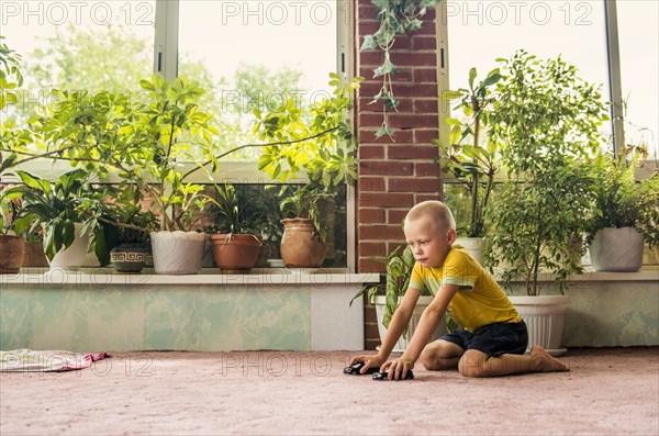 Caucasian boy playing with toy cars on floor