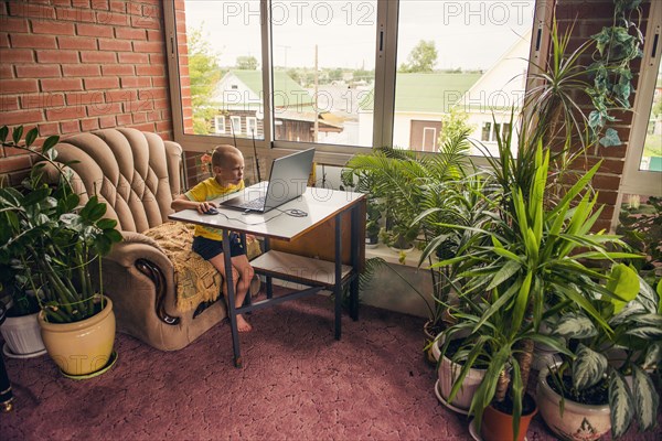 Caucasian boy using laptop at desk