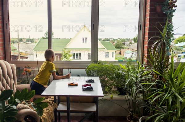 Caucasian boy playing with toy cars at desk