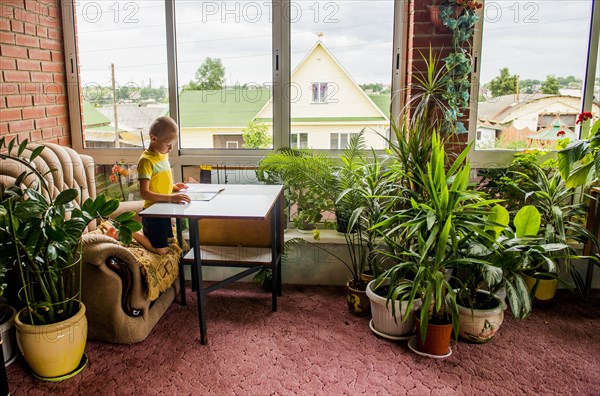 Caucasian boy reading magazine at desk