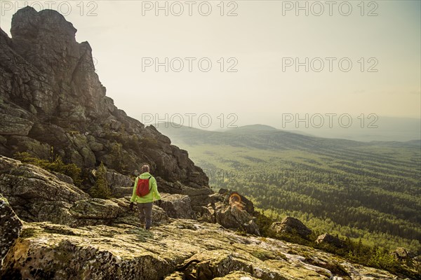 Caucasian hiker walking on rocky hillside in remote landscape