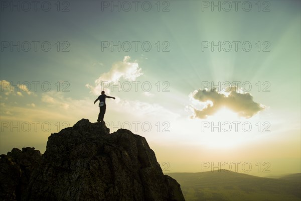 Caucasian hiker on rocky hilltop in remote landscape