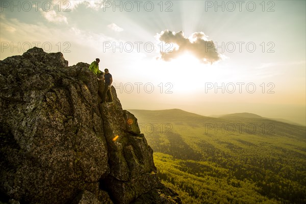 Caucasian hikers on rocky hilltop in remote landscape