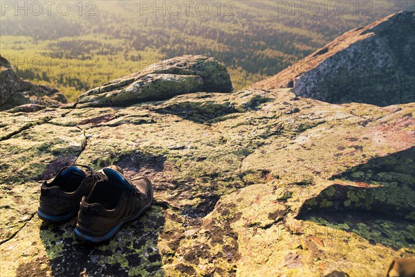 Close up of sneakers on rocky hilltop in remote landscape