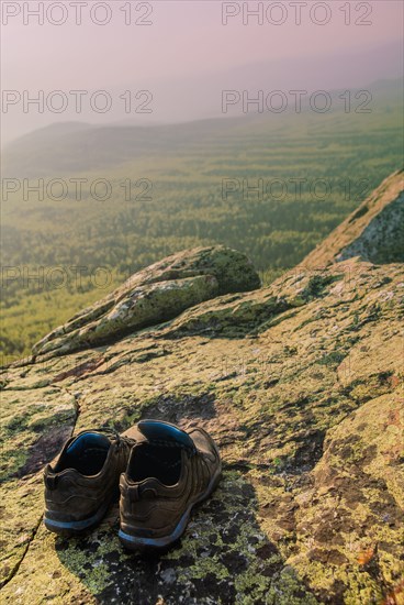 Close up of sneakers on rocky hilltop in remote landscape