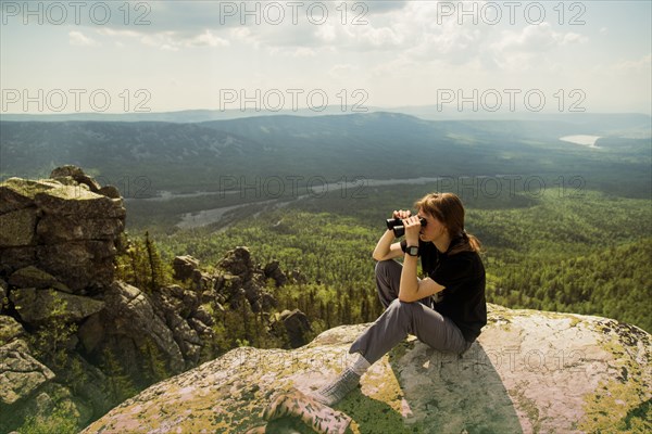 Caucasian hiker admiring remote landscape from rocky hilltop