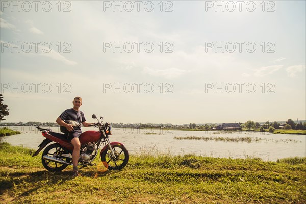 Caucasian man sitting on motorcycle in park